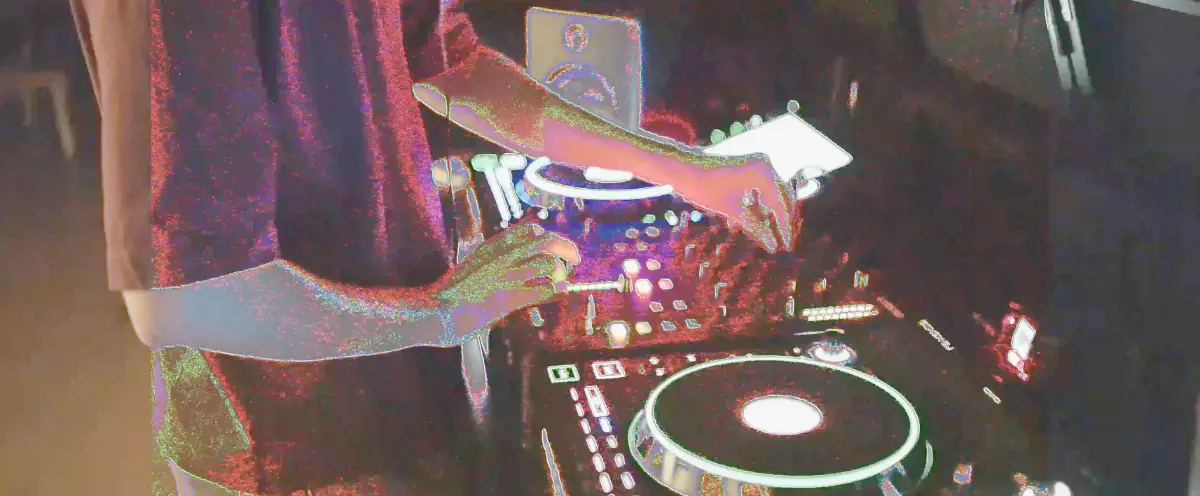 Mains d'un DJ aux platines lors d'un bal de promo lycéen — ambiance de soirée filmée par notre équipe vidéo